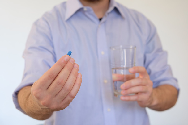 Man taking a pill with water - Fotoğraf, Görsel