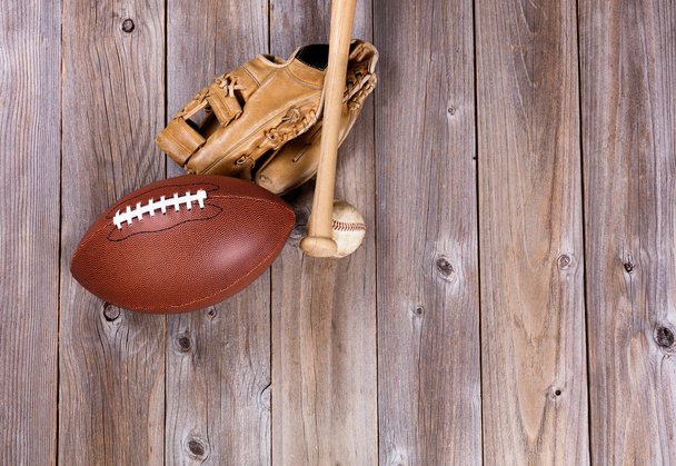 Football and baseball equipment on rustic wooden boards - Fotoğraf, Görsel