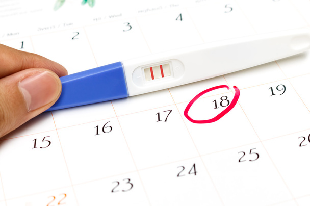 Δοκιμή εγκυμοσύνης με θετικό αποτέλεσμα που βρίσκεται στο ημερολόγιο - Φωτογραφία, εικόνα