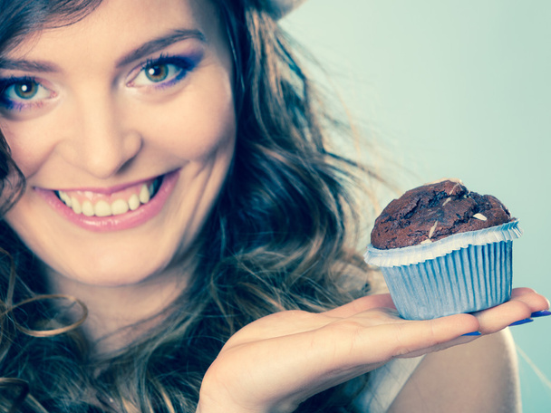 Smiling woman holds chocolate cake in hand - Фото, зображення
