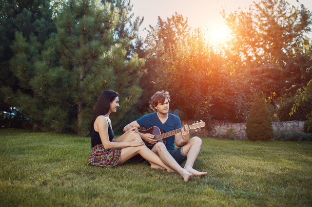 Romantikus pár ül a fűben, a kertben - Fotó, kép