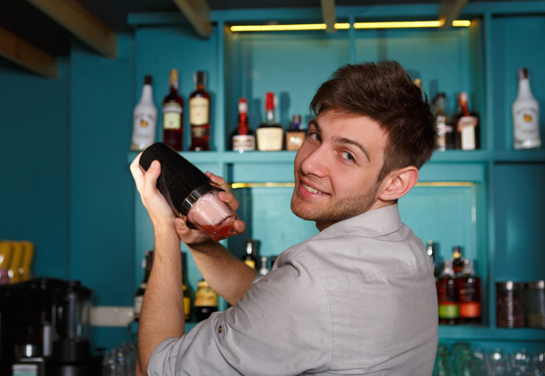Giovane bel barman in bar scuotendo e mescolando cocktail alcolici
 - Foto, immagini