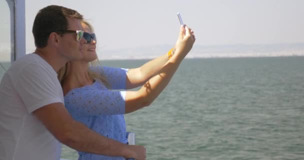 On sea in city of Perea, Greece on a ship young couple doing selfie on a mobile phone - Video