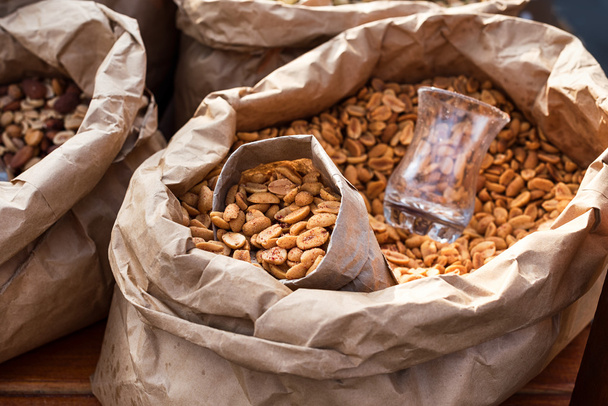 Amendoins salgados em um saco de papel closeup. Comida de rua
. - Foto, Imagem