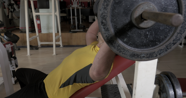 Joven en el gimnasio haciendo ejercicio de presión en el pecho con varilla
 - Imágenes, Vídeo