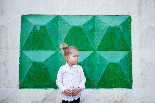 the child stands against the wall - Фото, зображення