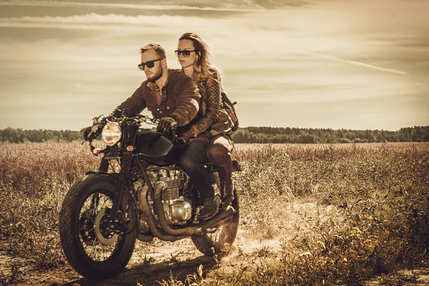 Stylish cafe racer couple on the vintage custom motorcycle - Photo, Image