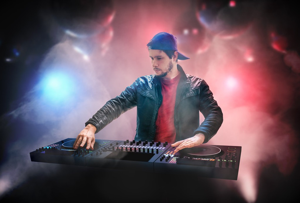 DJ (Disk Jockey) is mixing music in nightclub. - Φωτογραφία, εικόνα