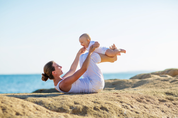 mother and son doing exercises on beach.  - Photo, Image