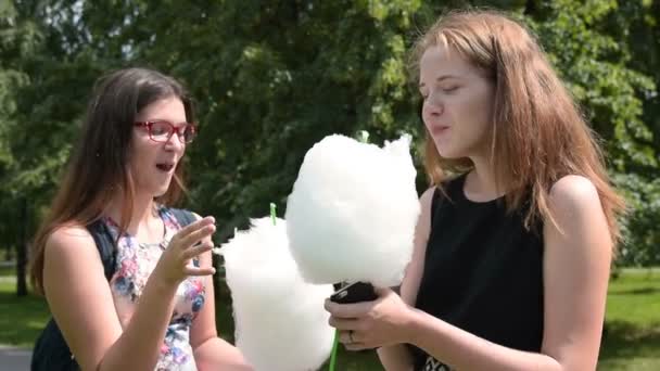 Girls eating cotton candy in the park - Záběry, video