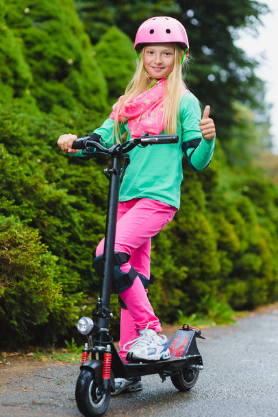 Happy girl standing on electric scooter outdoor - Zdjęcie, obraz