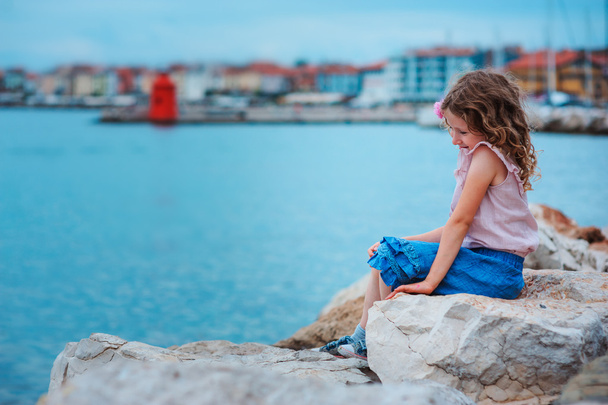 очаровательный мечтательный ребенок девочка отдыхает на пляже
 - Фото, изображение