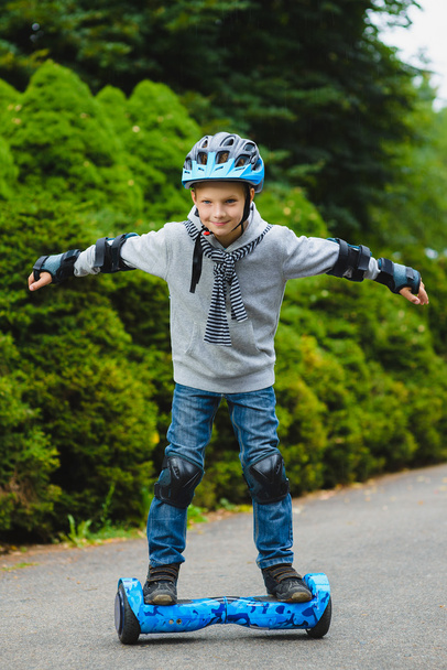 Happy boy riding on hoverboard or gyroscooter outdoor - Foto, imagen
