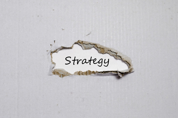 Das Wort Strategie taucht hinter zerrissenem Papier auf - Foto, Bild