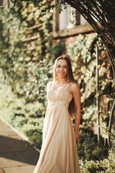 Attractive young woman with long dress enjoying her time outside in park sunset background - Foto, afbeelding