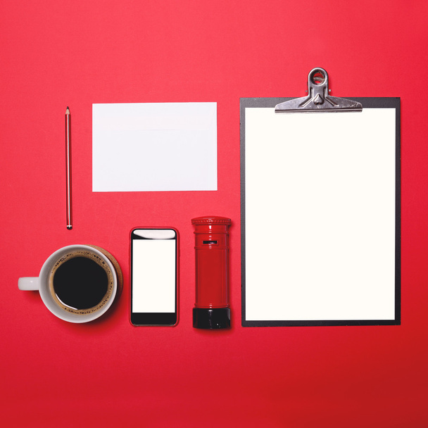 flache Arbeitsplatzlage im Büro mit Postzubehör auf rotem B - Foto, Bild