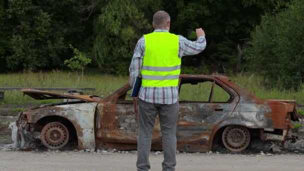 Inspetor tirar fotos de naufrágio de carro queimado no lado da estrada
 - Filmagem, Vídeo