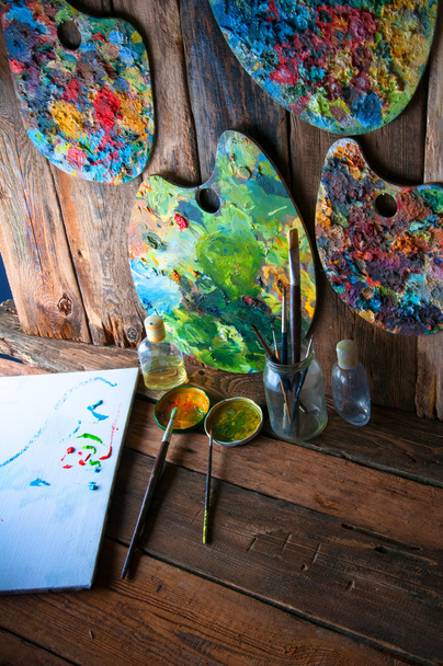 Palettes, brushes and canvas in an old painting workshop - Photo, Image