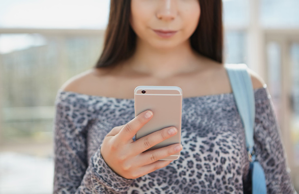 Brunette young girl using big silver modern smart phone  - Фото, изображение