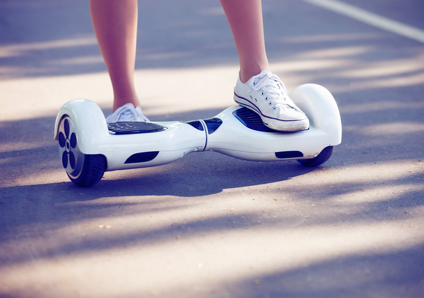 Feet of girl riding electric mini hoverboard scooter - Photo, Image