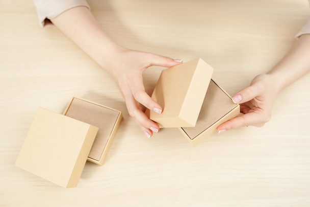 Female hands opening carton box, flat lay - Foto, Bild