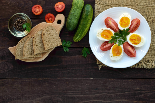 ゆで卵と新鮮なトマト、黒パン - 軽いダイエット朝食。トップビュー - 写真・画像