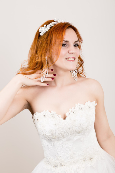 red-haired bride in a wedding dress, bright unusual appearance. Beautiful wedding hairstyle and bright make-up - Foto, Bild