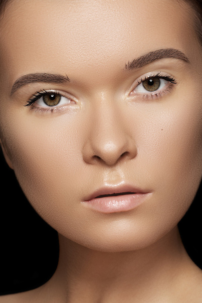 Spa, skincare, wellness, health & tan. Close-up portrait of beautiful female model face with purity health skin & light make-up on black background - Photo, image