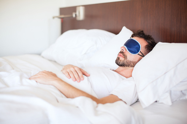 man met een baard met een slaap masker  - Foto, afbeelding