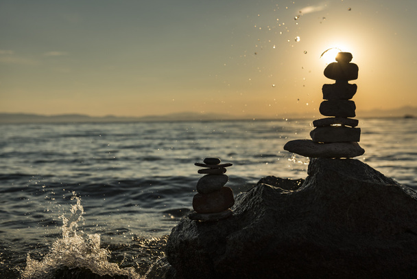 zen stacked stones and sunrise on the lake shore - Photo, Image