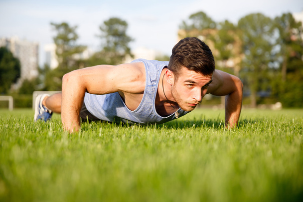 young athlete doing push-ups on grass - Foto, Imagen