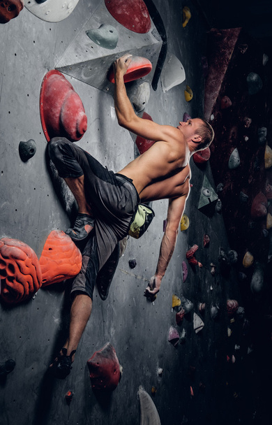 erkek üzerinde kapalı bir tırmanma duvarı tırmanışı - Fotoğraf, Görsel