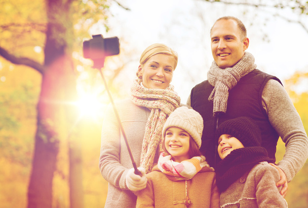 happy family with smartphone and monopod in park - Foto, Imagem