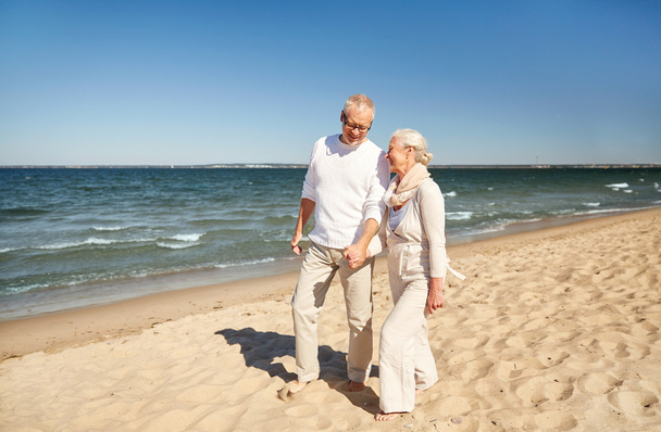 счастливая пожилая пара, гуляющая по летнему пляжу
 - Фото, изображение