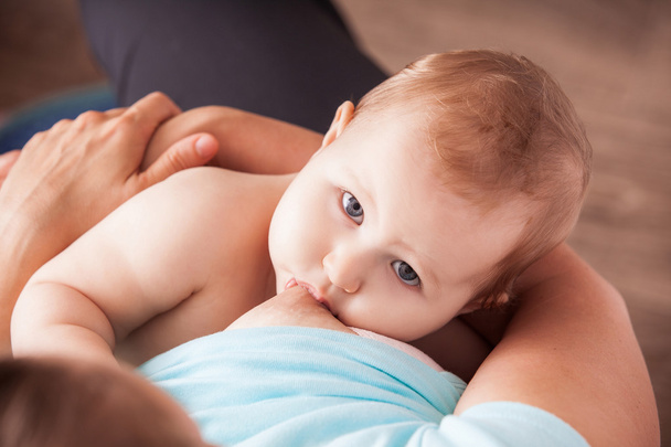 A young woman breast-feeding a baby - Фото, изображение