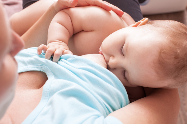 A young woman breast-feeding a baby - Φωτογραφία, εικόνα