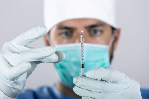 cirurgião médico com seringa na frente da face
 - Foto, Imagem