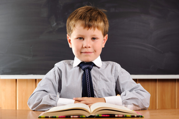 Cute boy with books at the desk - Photo, Image