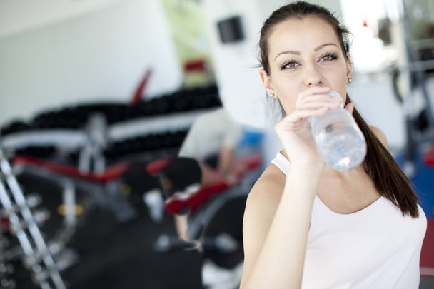 Fille boire de l'eau dans la salle de gym
 - Photo, image