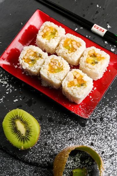 Sushi rolls topped with sweet sauce on a stone plate, view from the top - Φωτογραφία, εικόνα