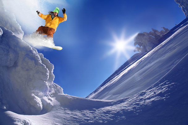 Snowboarder saltando contra o céu azul
 - Foto, Imagem