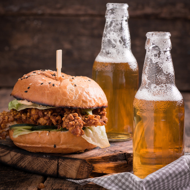 Fresh and tasty hamburger with a beer on a wooden table. - Foto, Bild
