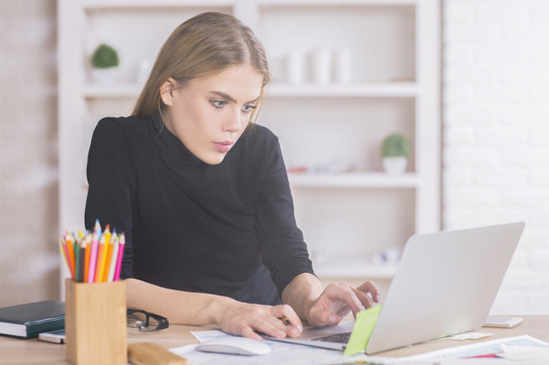 Girl using laptop at desk - Zdjęcie, obraz