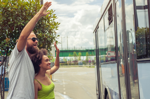 Young couple waving goodbye to their friends on the bus - Fotografie, Obrázek