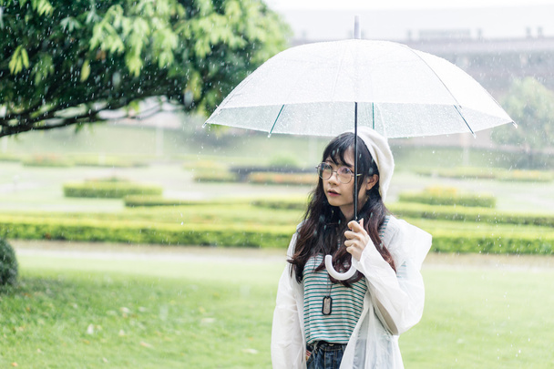 Очаровательная азиатка с зонтиком и плащом
  - Фото, изображение