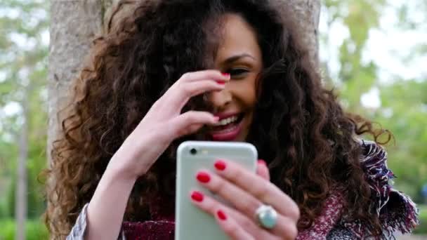 Portrét krásné mladé ženy s selfie s chytrý telefon v parku - Záběry, video