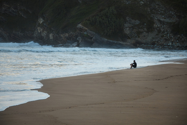 Surfeur assis au bord de la plage regardant vagues
 - Photo, image