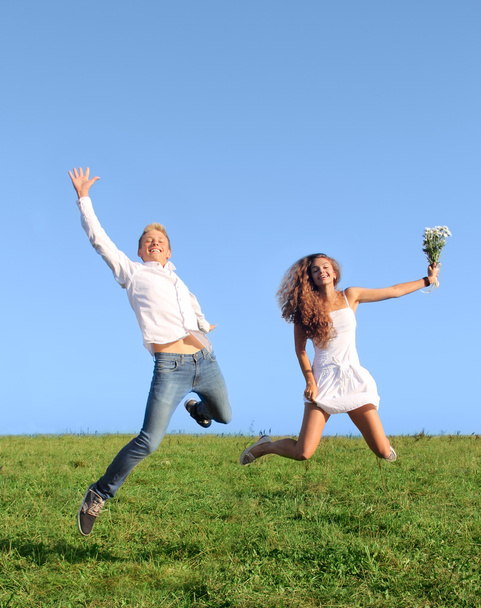 Young couple jumping on field - Foto, immagini