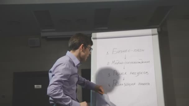Business man giving a presentation speech with flipchart in office - Materiał filmowy, wideo