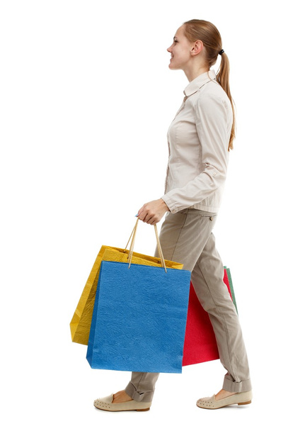 side view of going  woman  with shopping bags . - Foto, Imagen